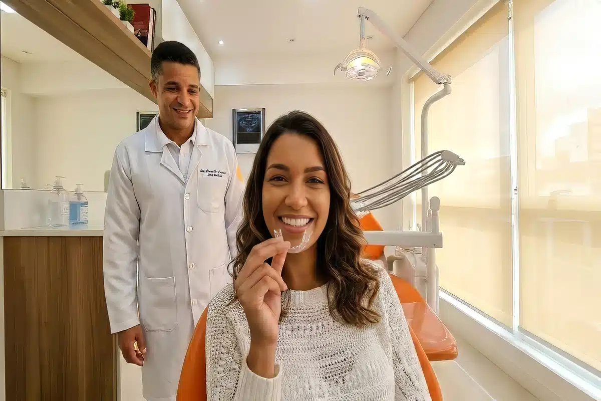 Paciente com alinhador invisível na cadeira odontológica e Dr. Marcello Mariano ao fundo na DENT+ Niterói